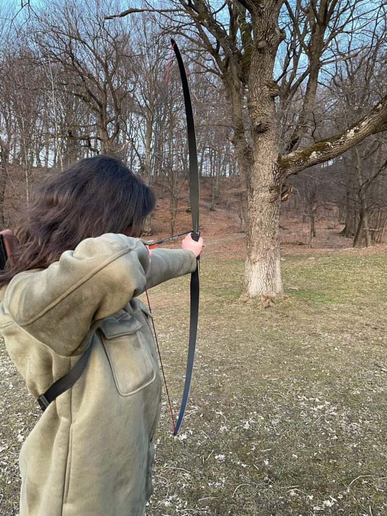 Andreea Stanga shooting with bow and arrow, photo used in context of smrtPhone services