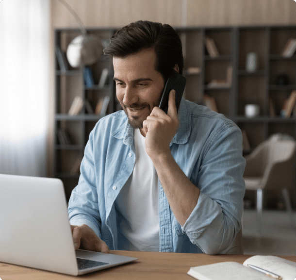 man talking on the phone while on his laptop